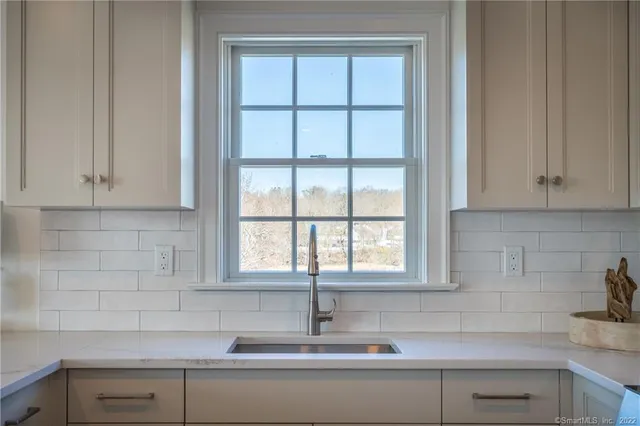 a kitchen with stainless steel appliances white cabinets and a window