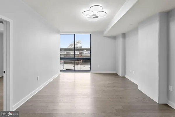 an empty room with wooden floor and ceiling fan