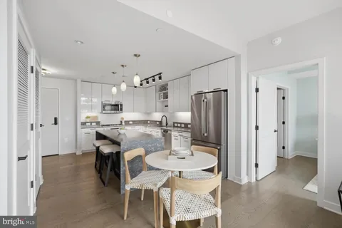 a kitchen with kitchen island a refrigerator and a dining table
