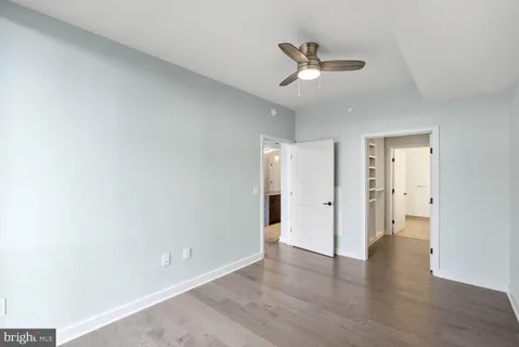 a bedroom with a bed painting on wall and a large window