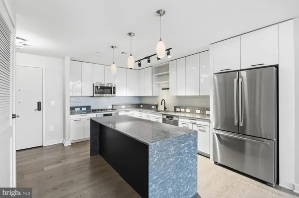 a view of kitchen with stainless steel appliances refrigerator and cabinets