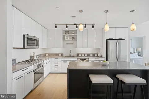 a kitchen with a white cabinets and chairs