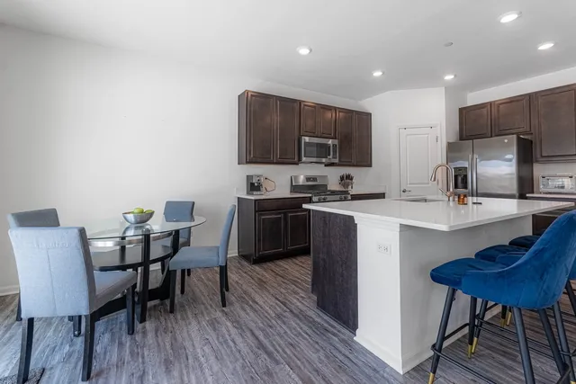 a kitchen with stainless steel appliances wooden cabinets a stove a microwave and a sink