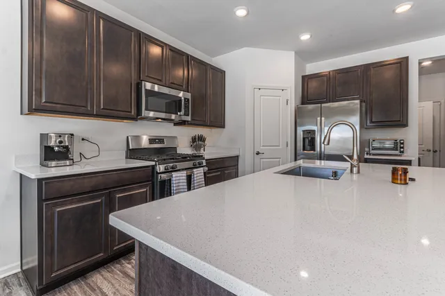 a kitchen with a sink and wooden floor