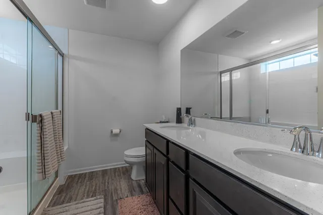 a bathroom with a granite countertop toilet and a shower