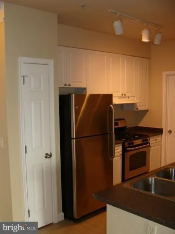 a kitchen with a refrigerator and a stove top oven