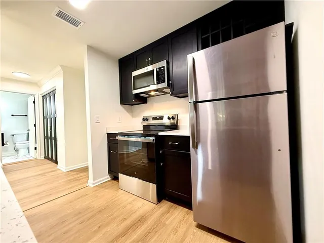 a kitchen with stainless steel appliances granite countertop a refrigerator and a sink