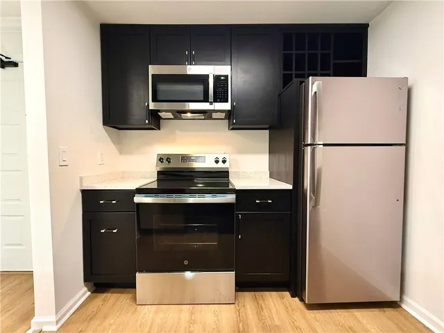 a kitchen with a refrigerator and a stove top oven