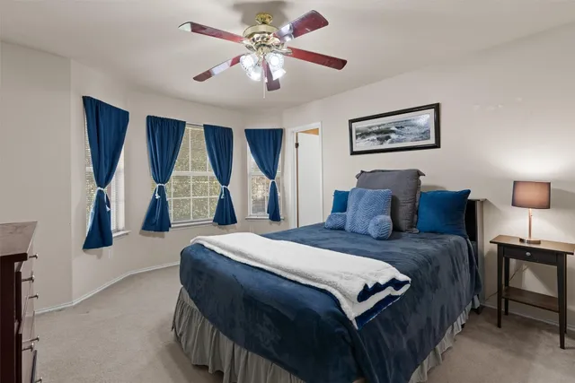 a spacious bedroom with a bed and a chandelier