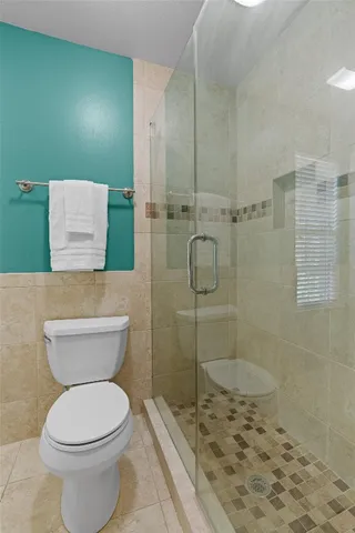 a bathroom with a toilet and a shower