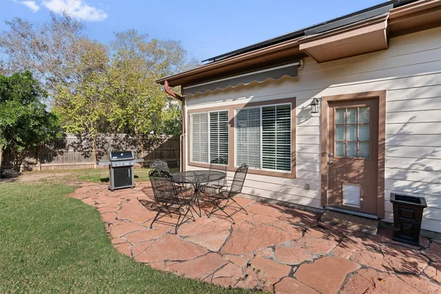 a view of house with backyard and sitting area