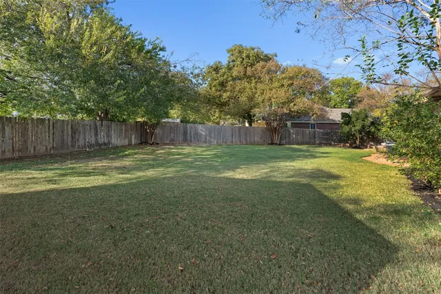 a view of a yard with a house in the background