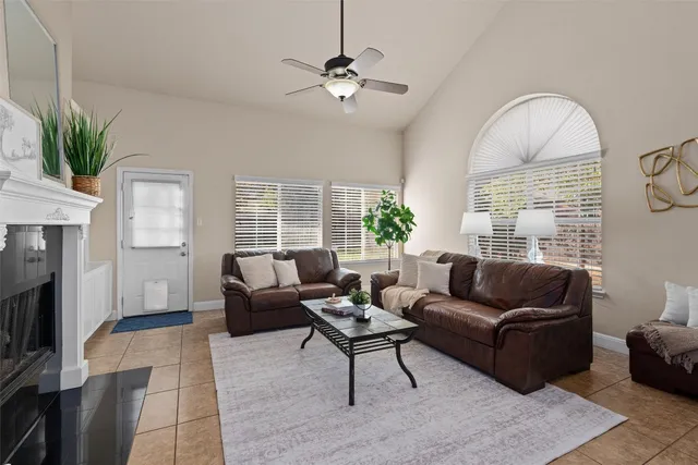 a living room with furniture a fireplace and a large window