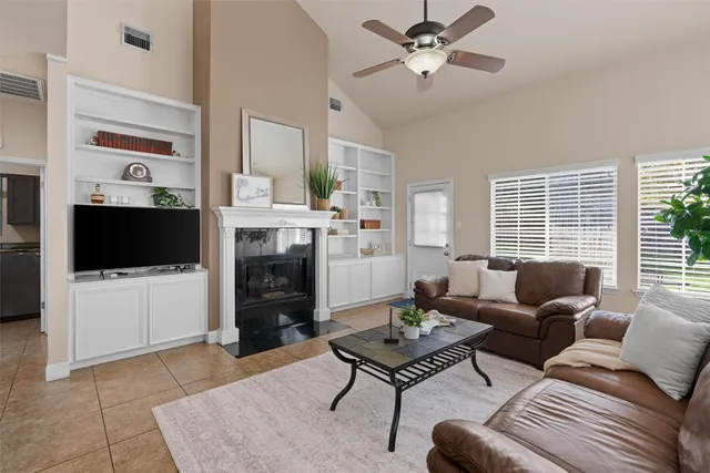 a living room with furniture a flat screen tv and a fireplace