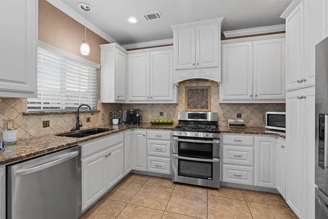 a kitchen with stainless steel appliances granite countertop a stove sink and cabinets