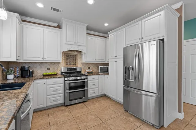 a kitchen with cabinets stainless steel appliances and a counter space