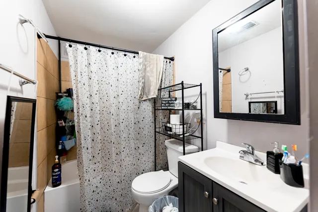 a bathroom with a sink a toilet and shower