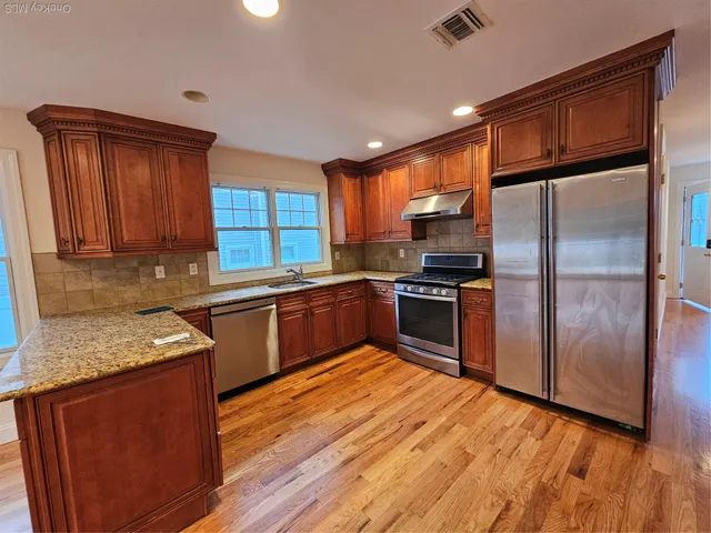a kitchen with granite countertop stainless steel appliances and wooden cabinets