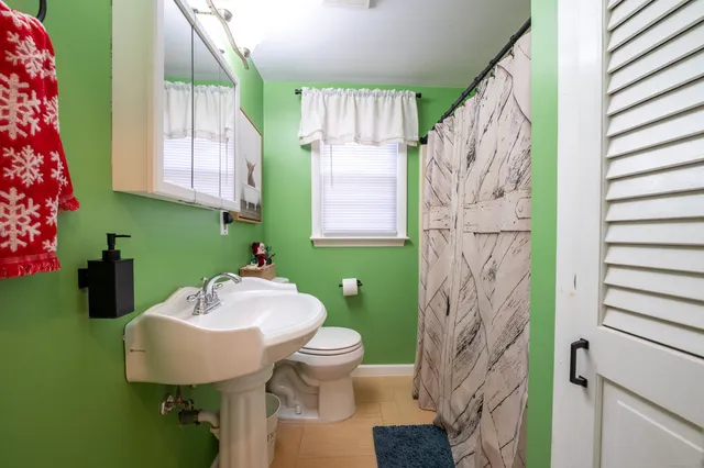 a bathroom with a sink toilet and a mirror