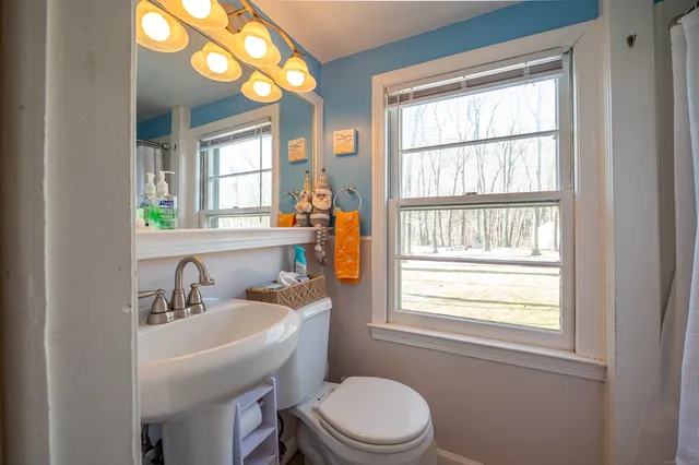 a bathroom with a sink a toilet and a window