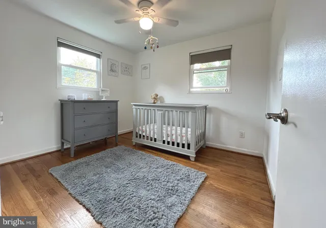 a view of a bedroom with wooden floor and a window