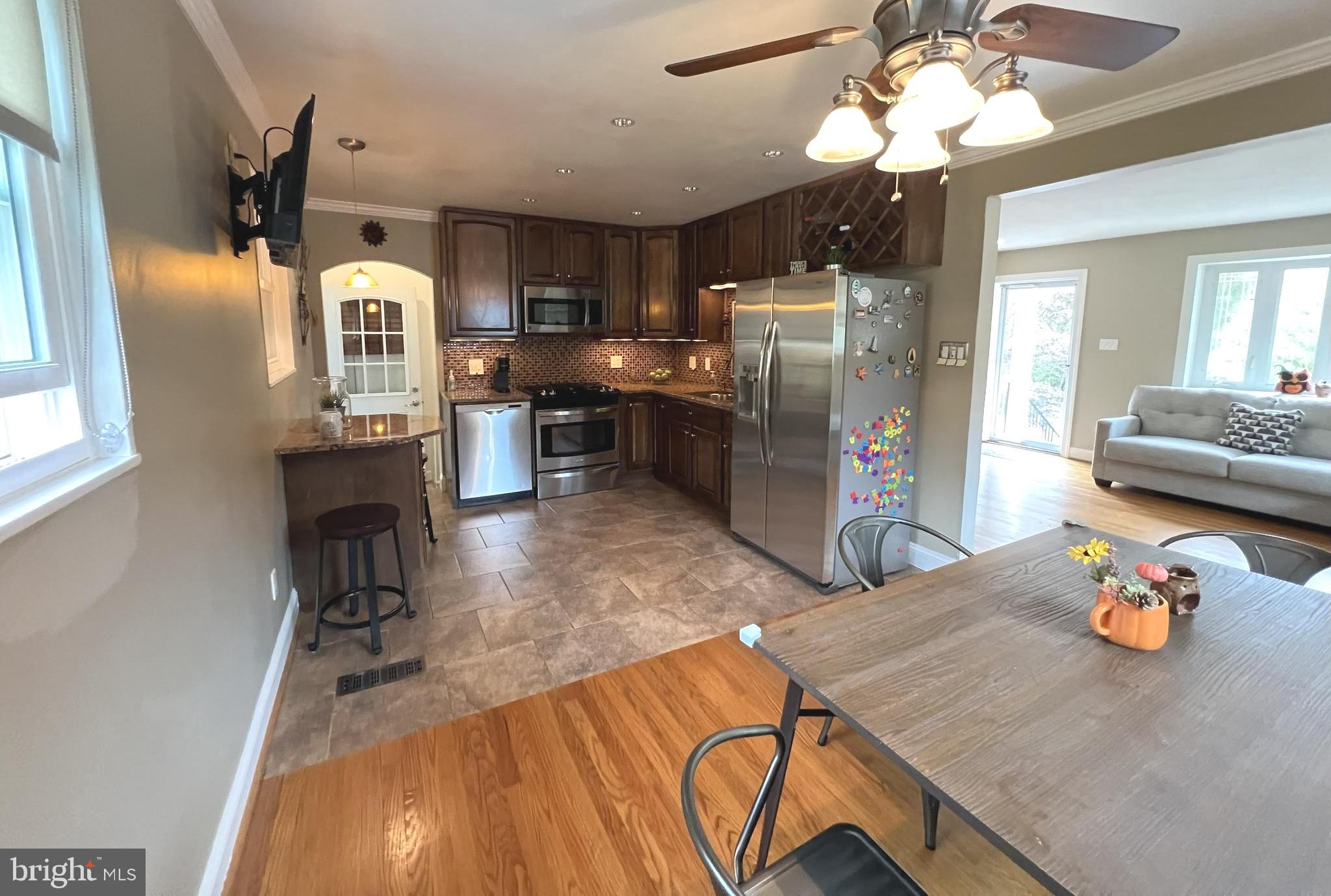 1001 Gabel Street Silver Spring, MD 20901 - Photo 25 of 46 a kitchen with stainless steel appliances wooden floor dining table and chairs