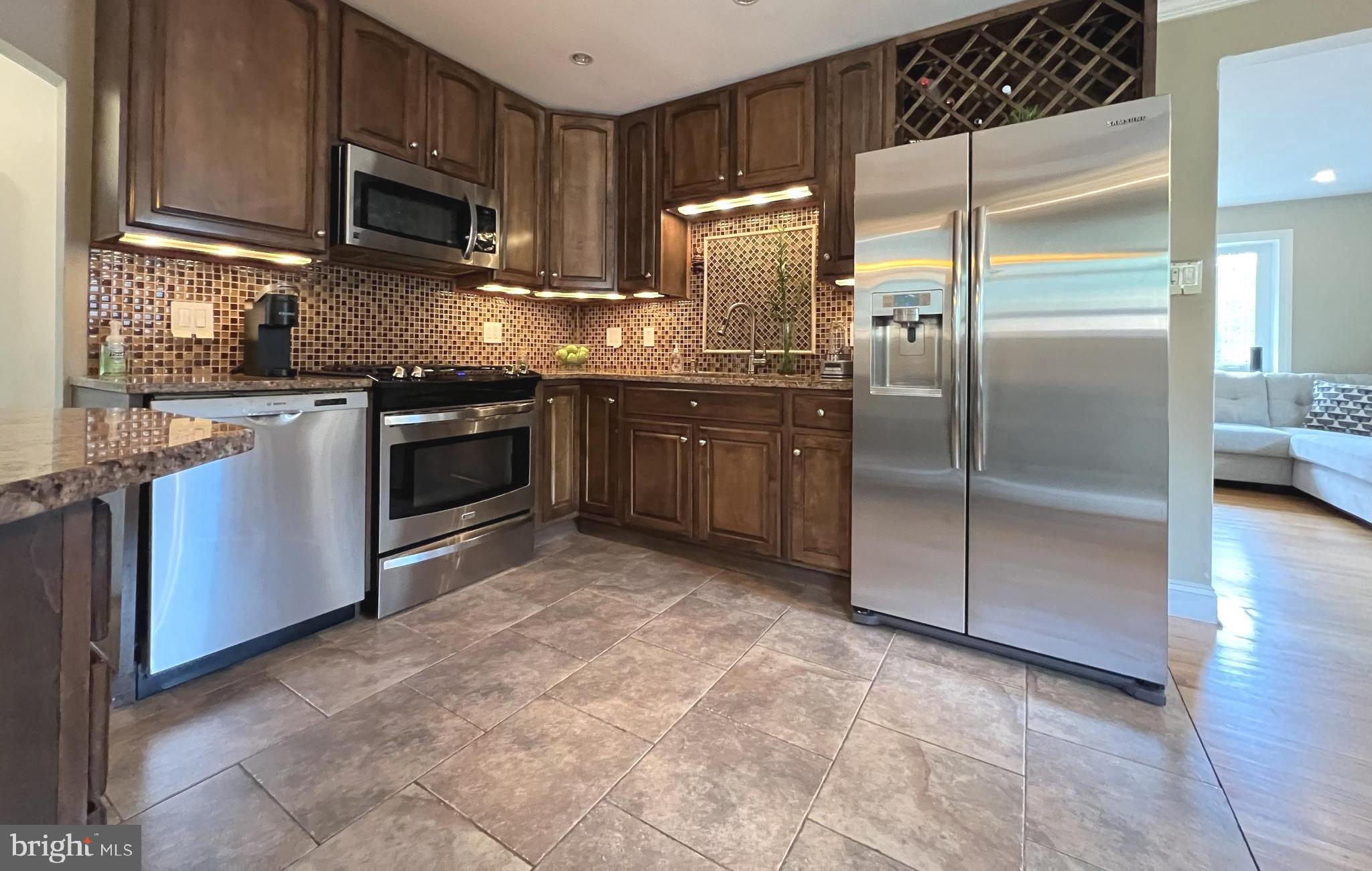 1001 Gabel Street Silver Spring, MD 20901 - Photo 27 of 46 a kitchen with stainless steel appliances granite countertop a refrigerator a stove a sink and a microwave