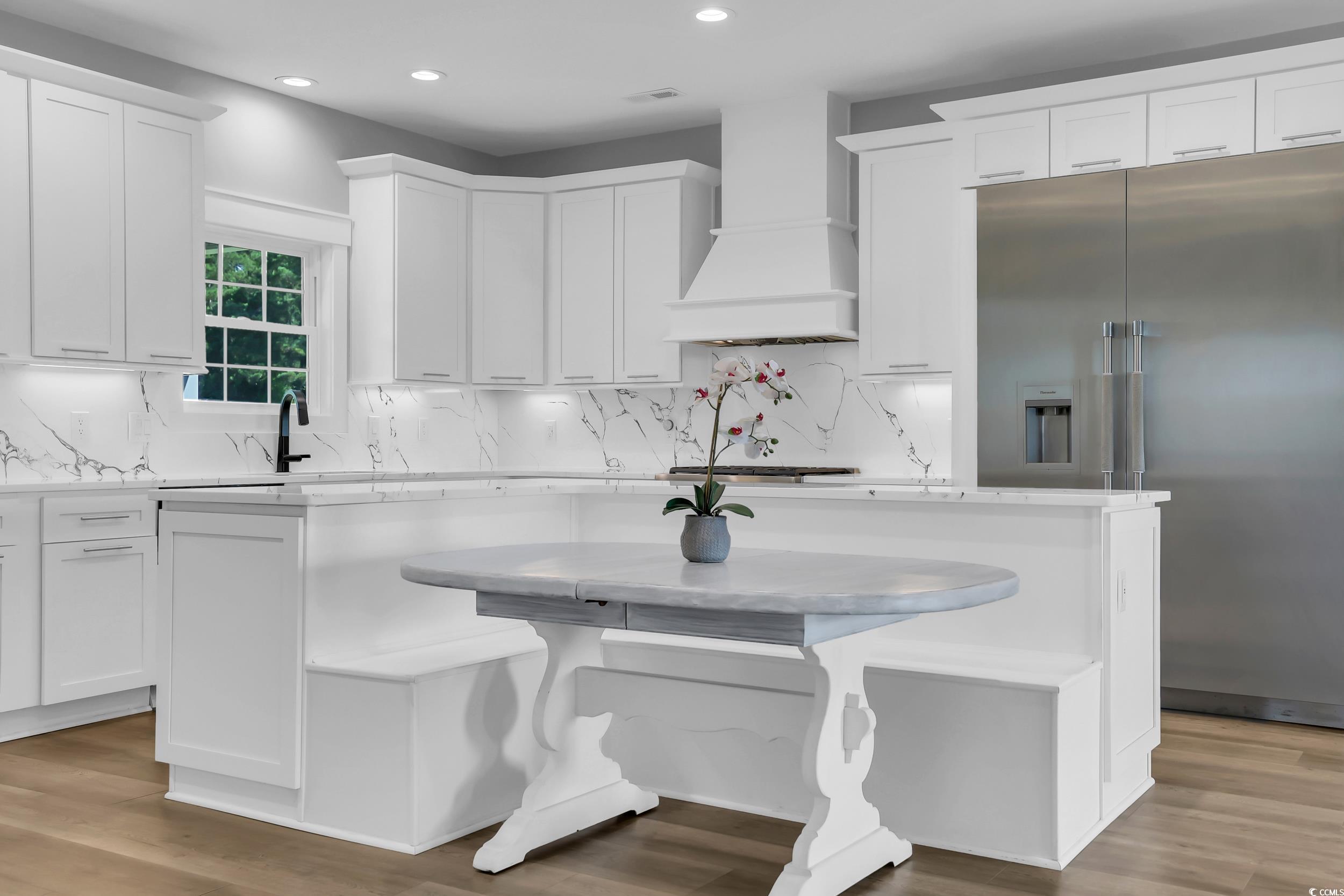 7356 Johnson Shortcut Road Conway, SC 29527 - Photo 13 of 40 Kitchen with appliances with stainless steel finishes, custom exhaust hood, a kitchen island, white cabinetry, and decorative backsplash