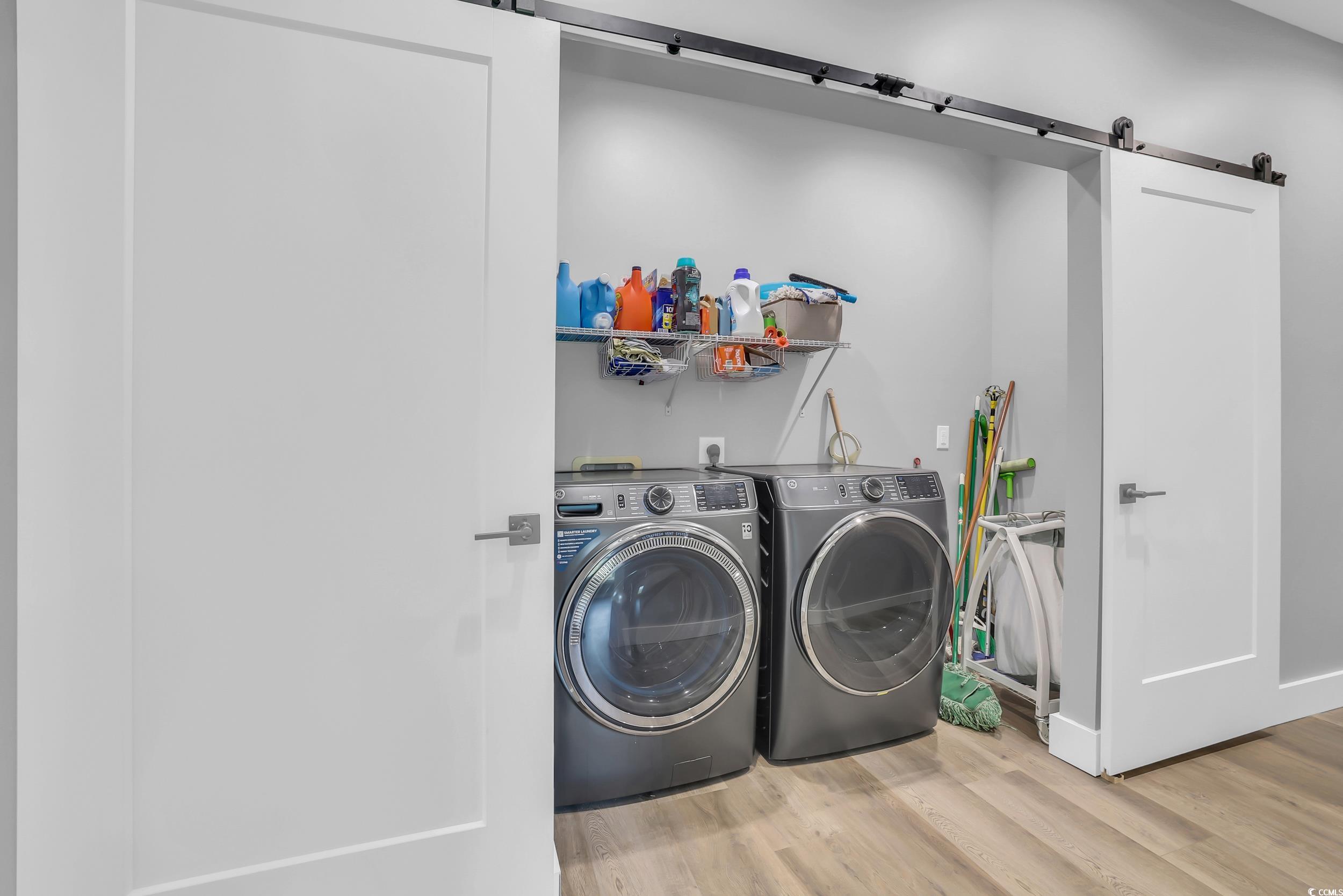 7356 Johnson Shortcut Road Conway, SC 29527 - Photo 23 of 40 Laundry room featuring a barn door, washing machine and clothes dryer, and wood finished floors