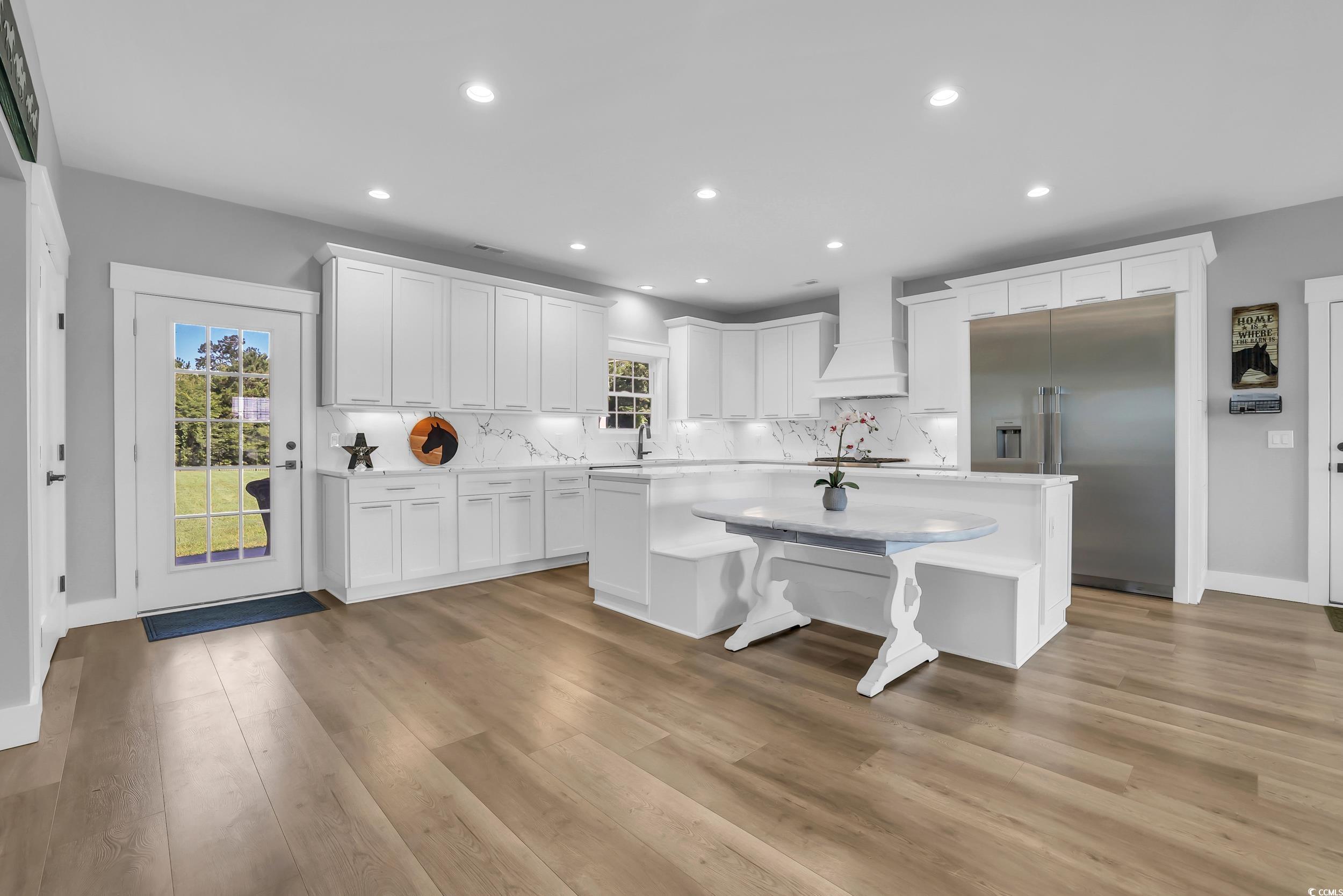 7356 Johnson Shortcut Road Conway, SC 29527 - Photo 8 of 40 Kitchen with built in fridge, custom exhaust hood, a center island, light countertops, and backsplash