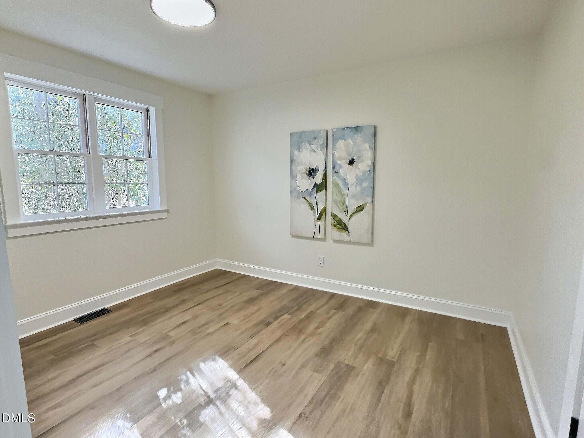 707 Wade Avenue Raleigh, NC 27605 - Photo 11 of 14 an empty room with wooden floor and window
