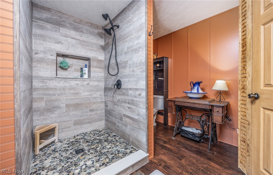 1788 Rosenbush Road Newport, OH 45768 - Photo 20 of 43 Walk-in shower featuring plank-style wall tile, a river rock floor, and a built-in niche