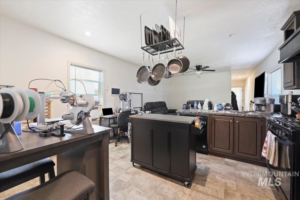424 West Cherry Lane, Unit 94 Meridian, ID 83642 - Photo 30 of 31 Kitchen with black appliances, open floor plan, a peninsula, a kitchen island, and a ceiling fan