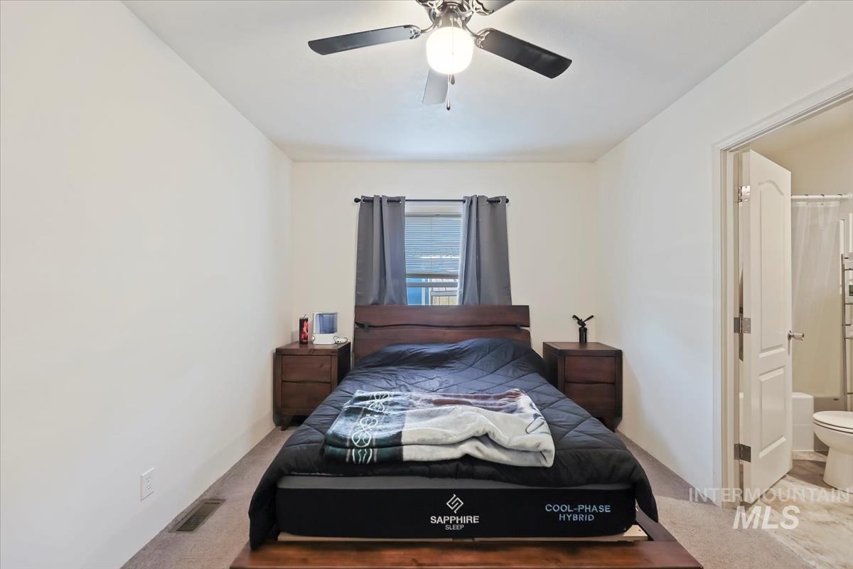 424 West Cherry Lane, Unit 94 Meridian, ID 83642 - Photo 18 of 31 Carpeted bedroom with ensuite bath and a ceiling fan