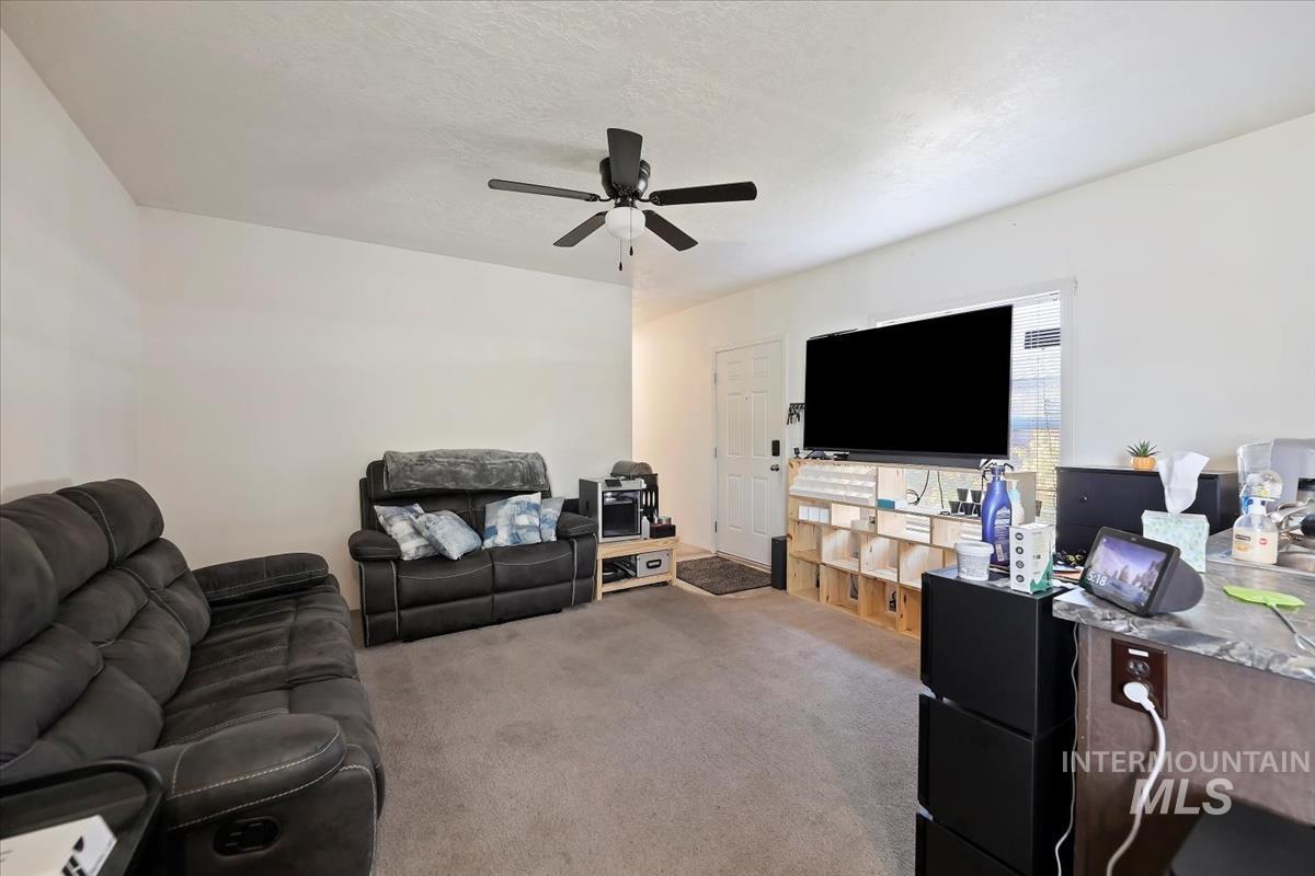 424 West Cherry Lane, Unit 94 Meridian, ID 83642 - Photo 6 of 31 Carpeted living room with a ceiling fan and a textured ceiling