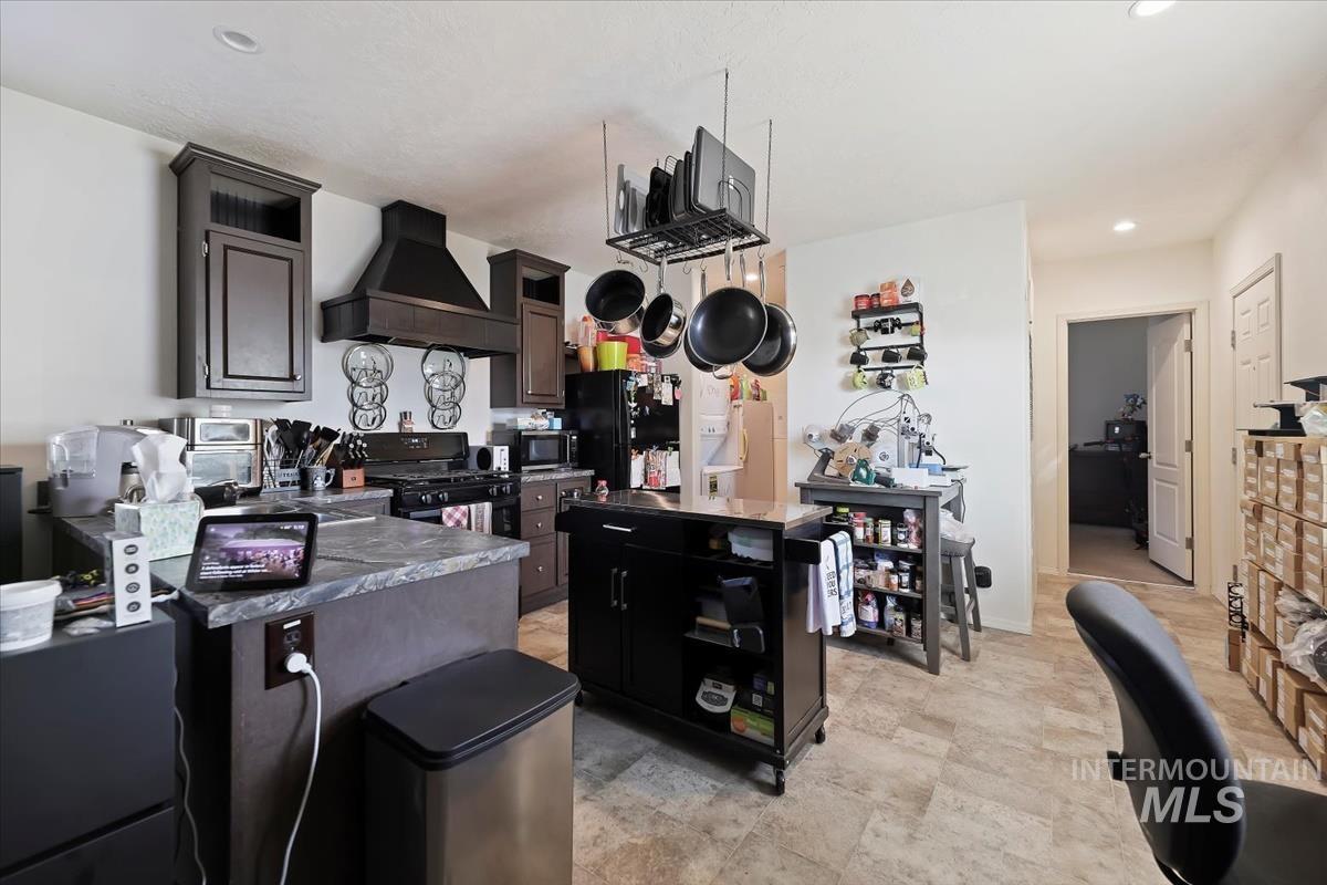 424 West Cherry Lane, Unit 94 Meridian, ID 83642 - Photo 7 of 31 Kitchen with premium range hood, a peninsula, recessed lighting, dark countertops, and a center island