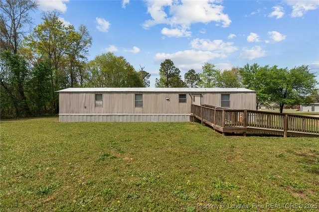 a view of a house with a garden and trees