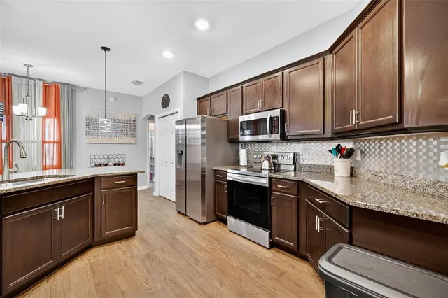 a kitchen with stainless steel appliances granite countertop a sink stove and refrigerator