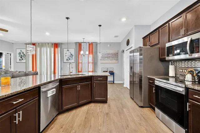 a large kitchen with stainless steel appliances granite countertop a stove a sink dishwasher and a refrigerator