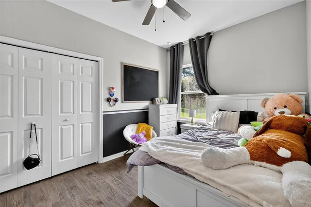 a bedroom with bed and a flat tv screen on dresser