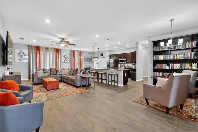 a living room with furniture kitchen view and a flat screen tv