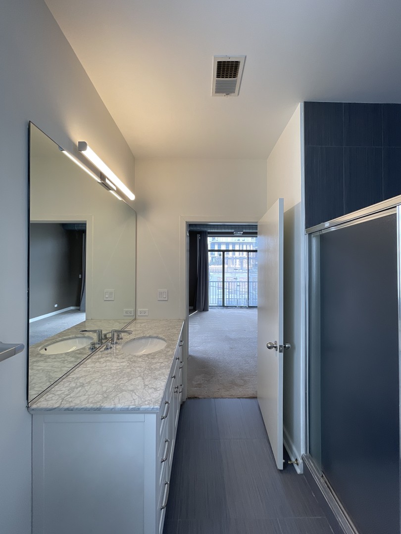 849 West Monroe Street, Unit 3F Chicago, IL 60607 - Photo 14 of 18 a bathroom with a granite countertop sink and a mirror