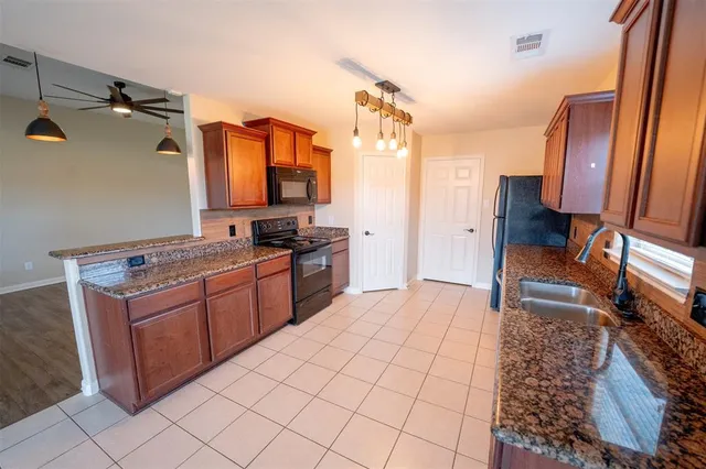 a kitchen with stainless steel appliances granite countertop a refrigerator and a stove top oven