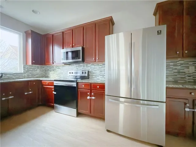 a kitchen with stainless steel appliances granite countertop a refrigerator a stove a sink and a granite counter tops