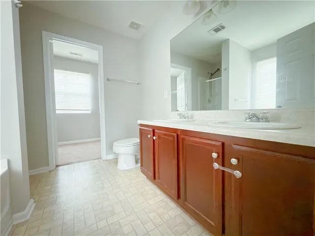 a bathroom with a sink a toilet a mirror and vanity