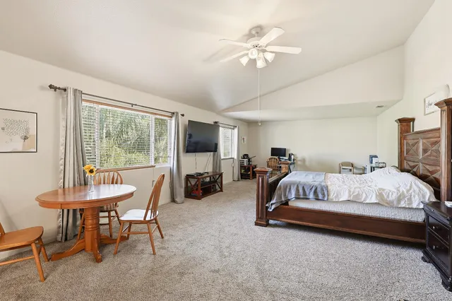 a spacious bedroom with a bed and a chandelier