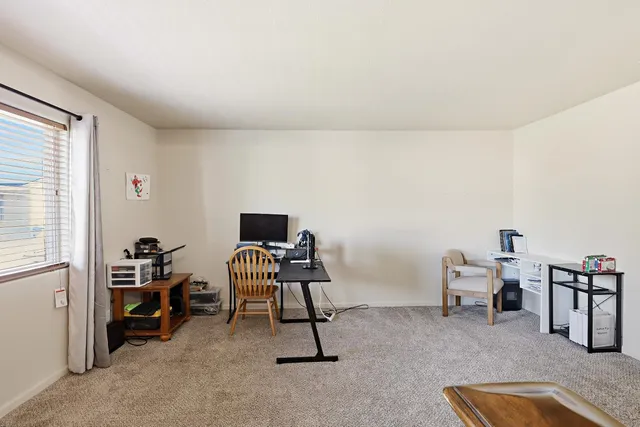 a livingroom with workspace and a window
