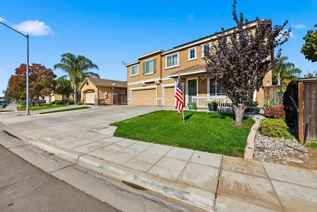a front view of a house with a yard and potted plants