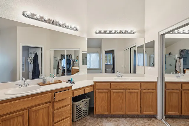 a spacious bathroom with a granite countertop sink a mirror and a bathtub