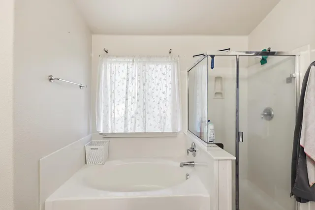 a white bath tub sitting next to a white sink and a shower